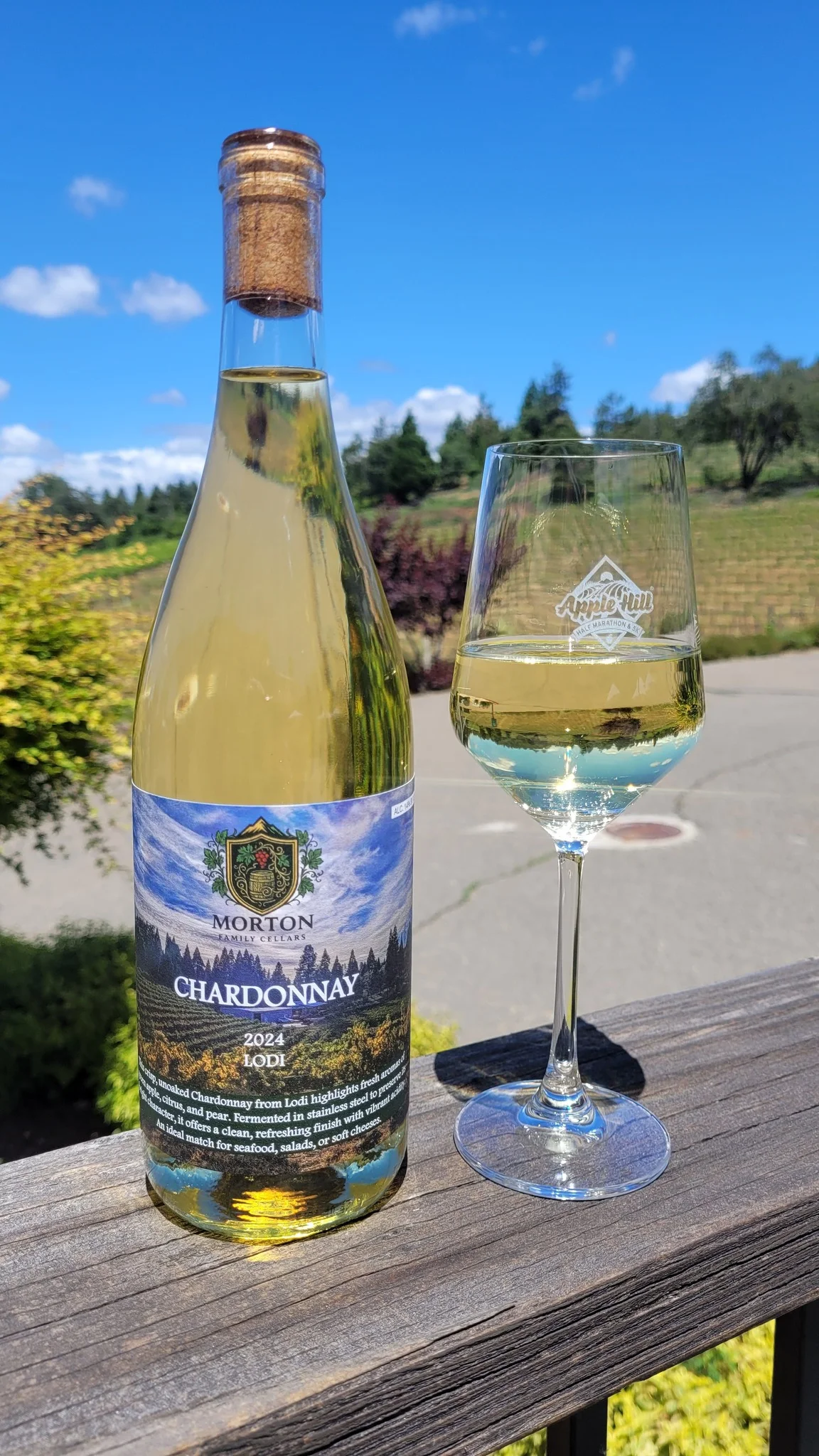 A bottle and glass of 2024 Chardonnay on the balcony