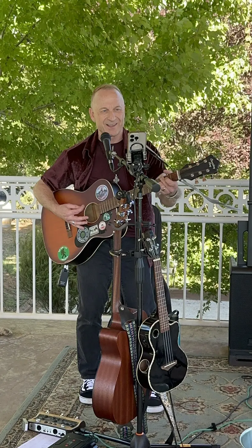 Doug from Crossing Autumn playing acoustic guitar on the patio