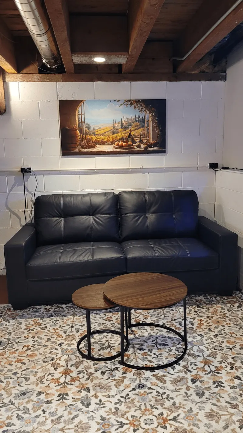 Speakeasy lounge seating area with Tuscan vineyard painting in the speakeasy tasting room