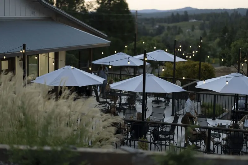 Evening patio dining with umbrella seating overlooking the vineyard